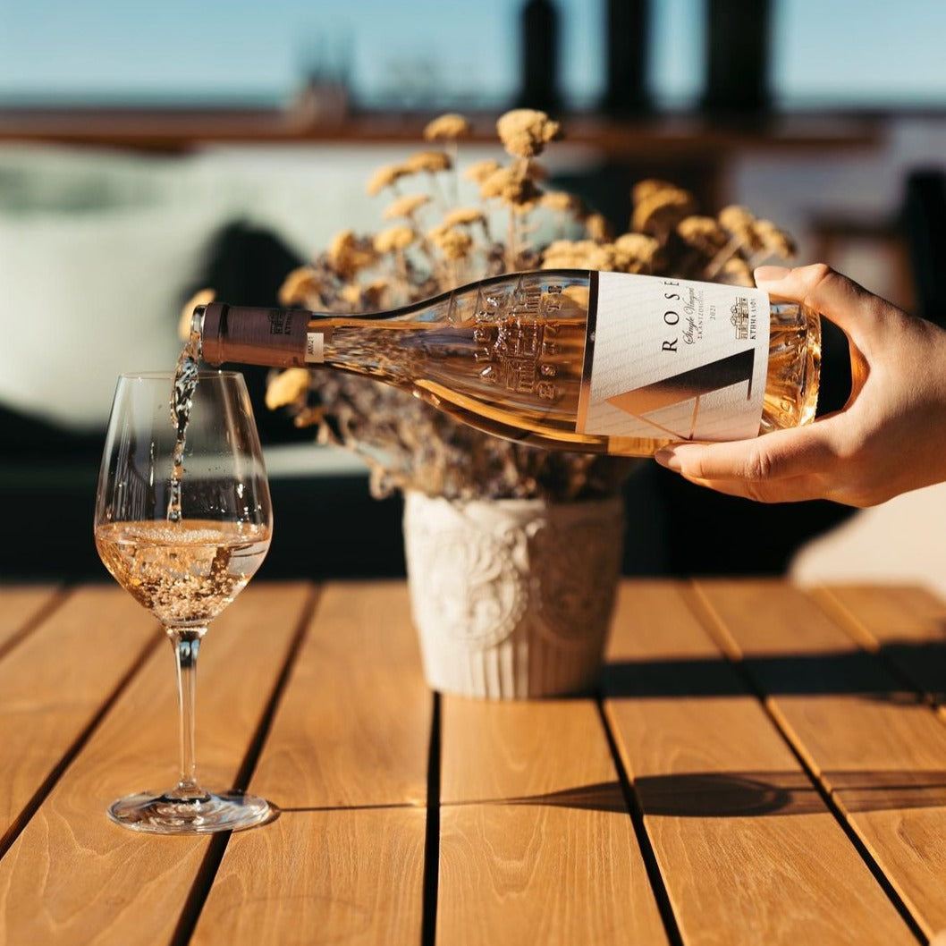 Alpha Estate Rosé Xinomavro 2022 beim Einschenken in Glas mit Terassenhintergrund und Sommerlicht