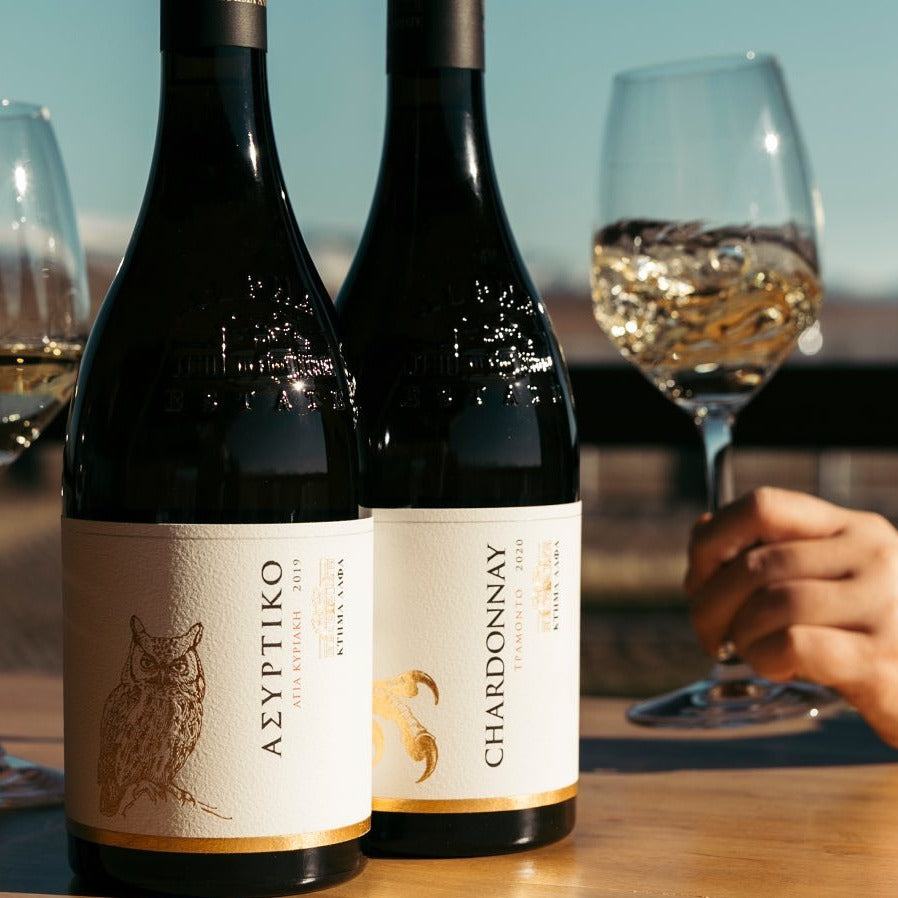 Ecosystem Chardonnay Alpha Estate Weinflaschen und Glas mit weißem Wein vor blauem Himmel