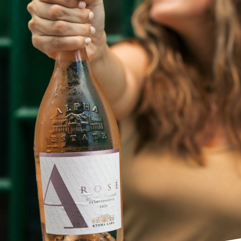 Alpha Estate Rosé Flasche mit zart lachsfarbenem Wein und Xinomavro 2022 Jahrgang, gehalten von Frau