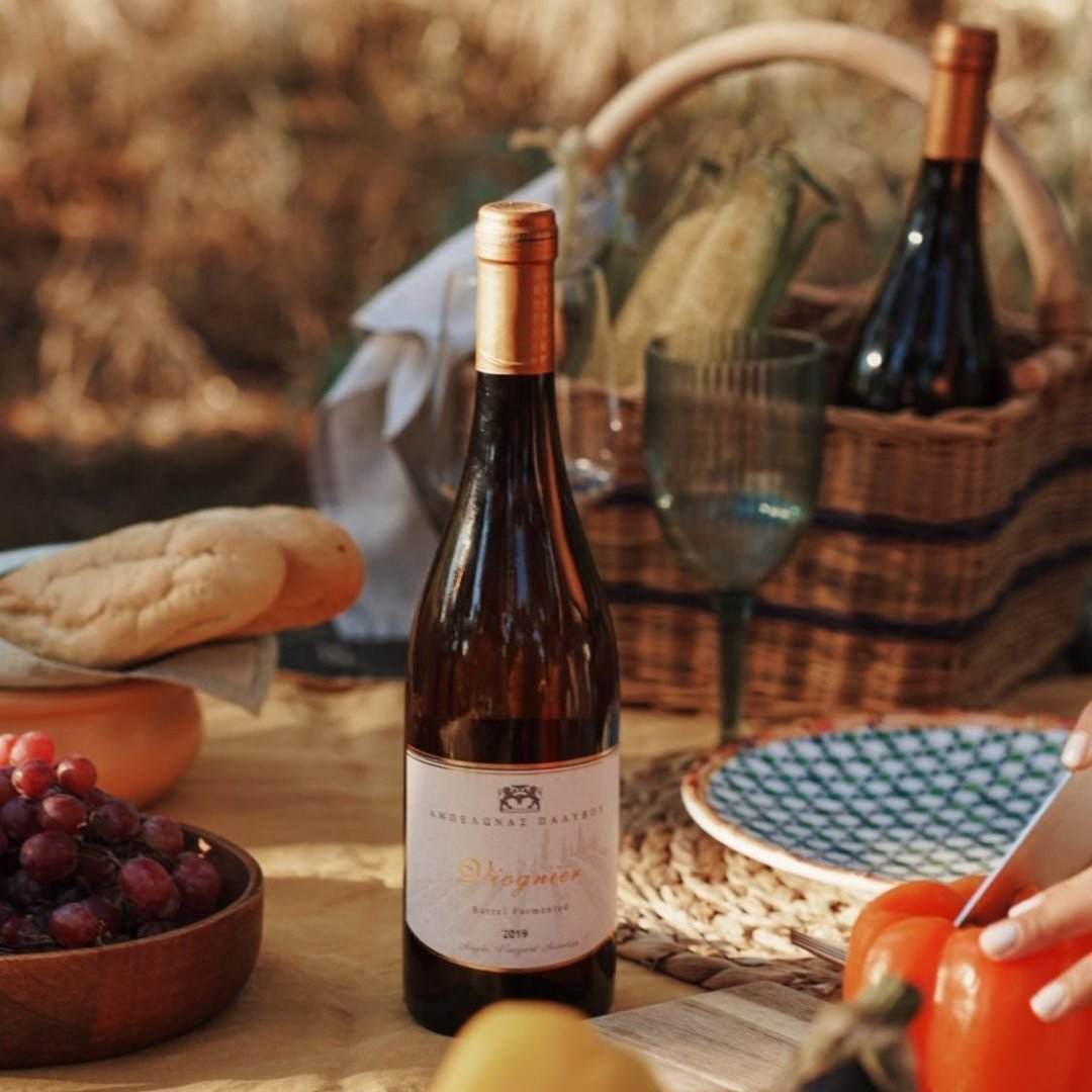 Viognier Palivou Estate Weißweinflasche auf Picknicktisch mit Trauben und Brot im Freien