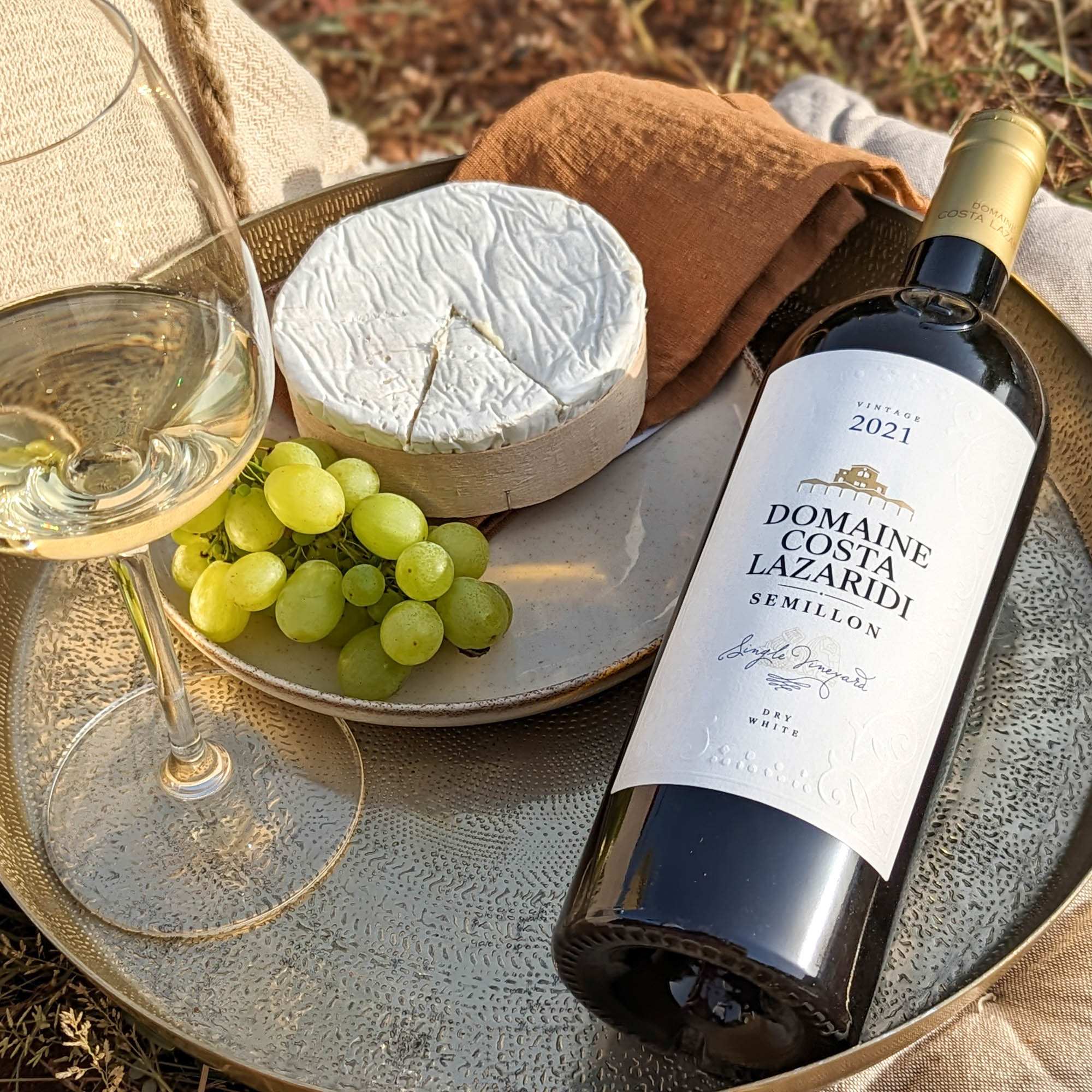 Semillon Domaine Costa Lazaridi Weißwein mit Käse und Trauben auf Metalltablett