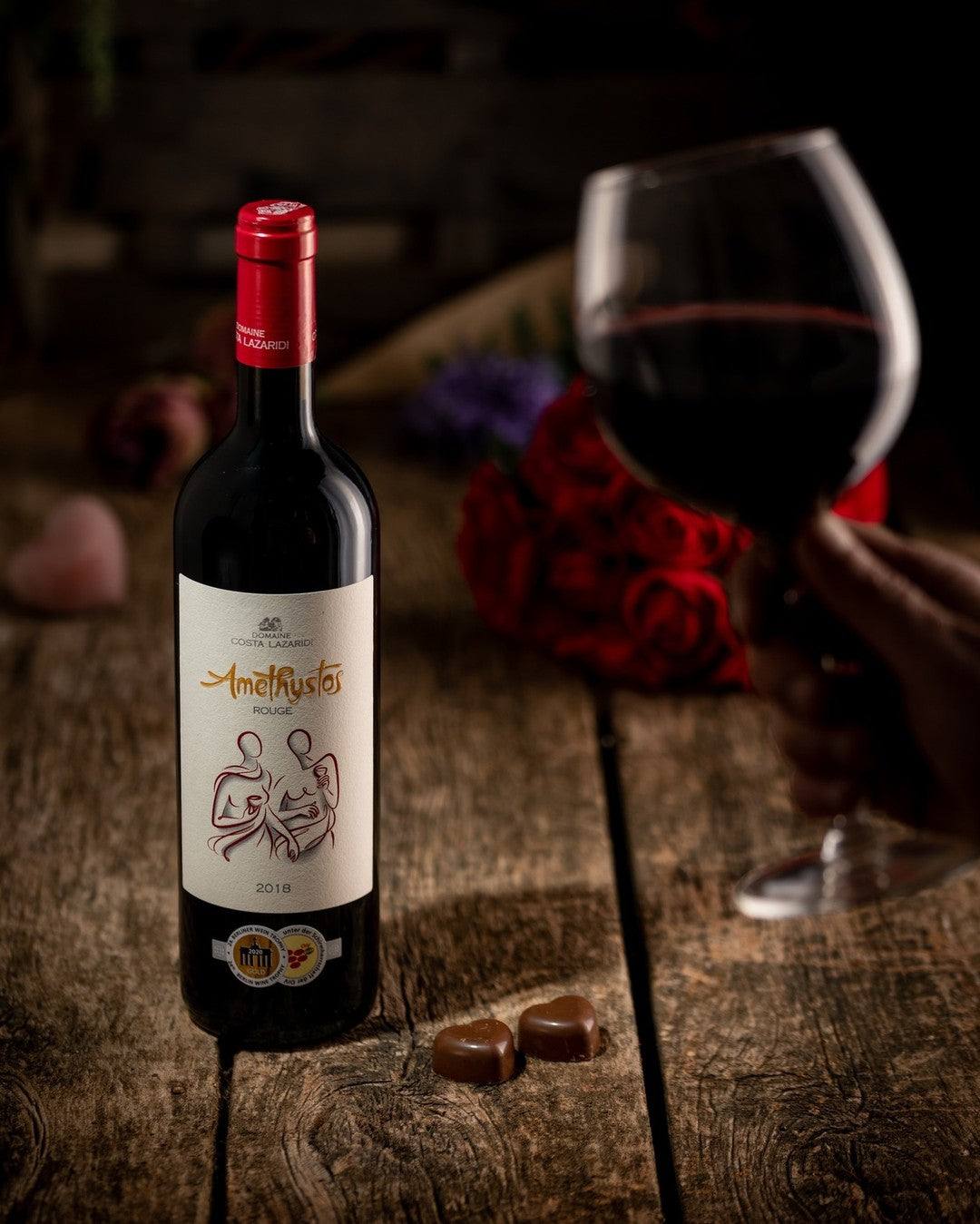 Amethystos Red Rotweinflasche mit Glas und Rosen auf Holztisch, trocken, Frucht- und Gewürzaromen, Jahrgang 2022, 14,5% Vol.