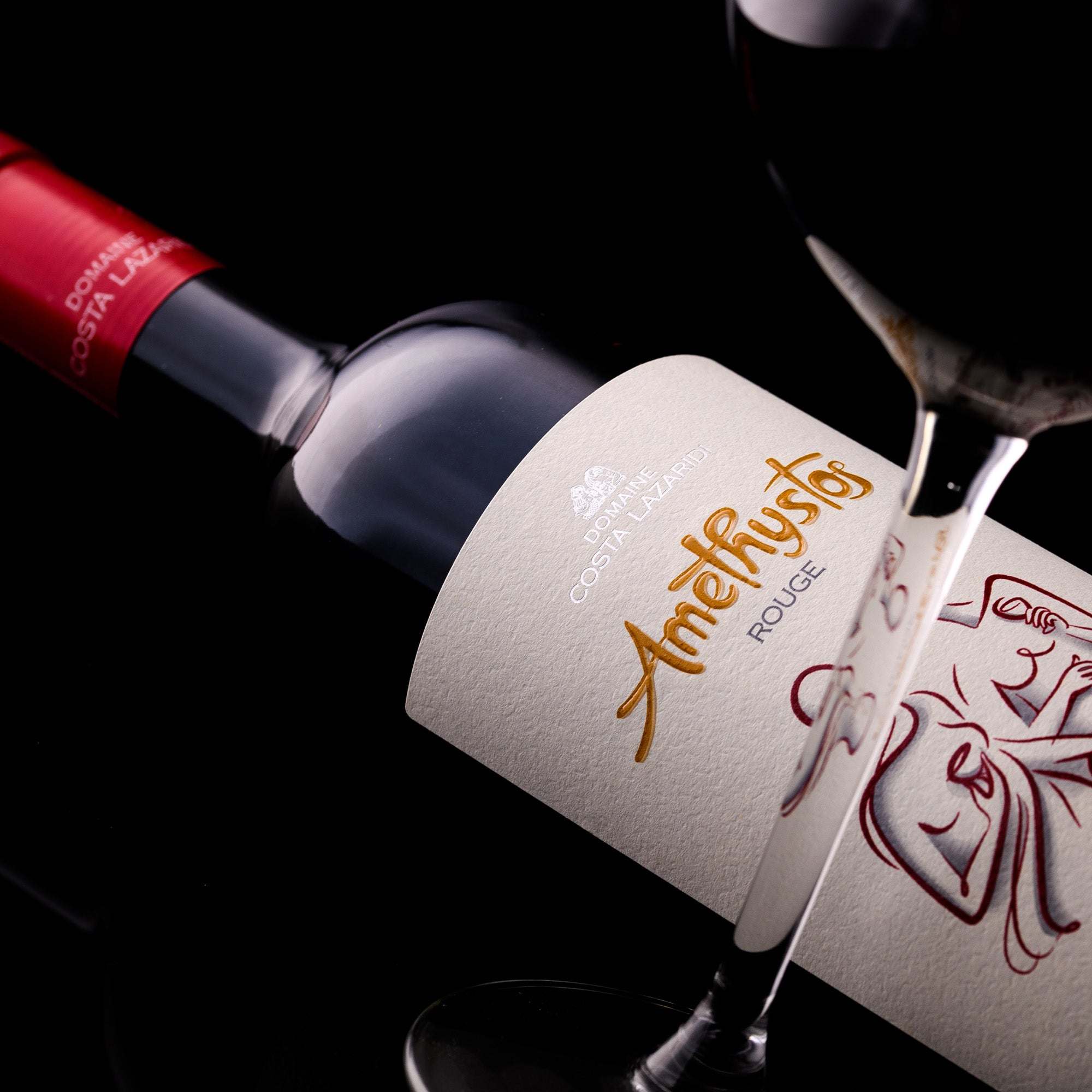 Flasche Amethystos Red Rotwein Domaine Costa Lazaridi mit Glas und dunklem Hintergrund