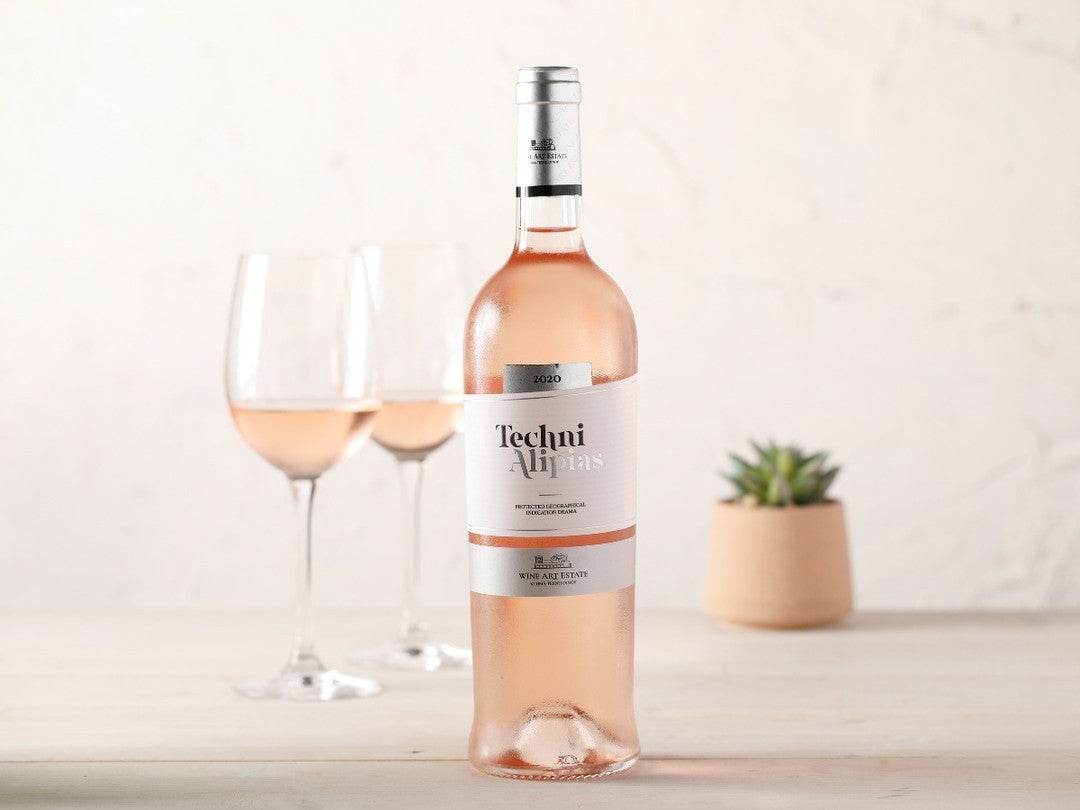 Flasche Techni Rosé 2024 Wein aus Drama PGI mit zwei Gläsern und kleiner Pflanze im Hintergrund