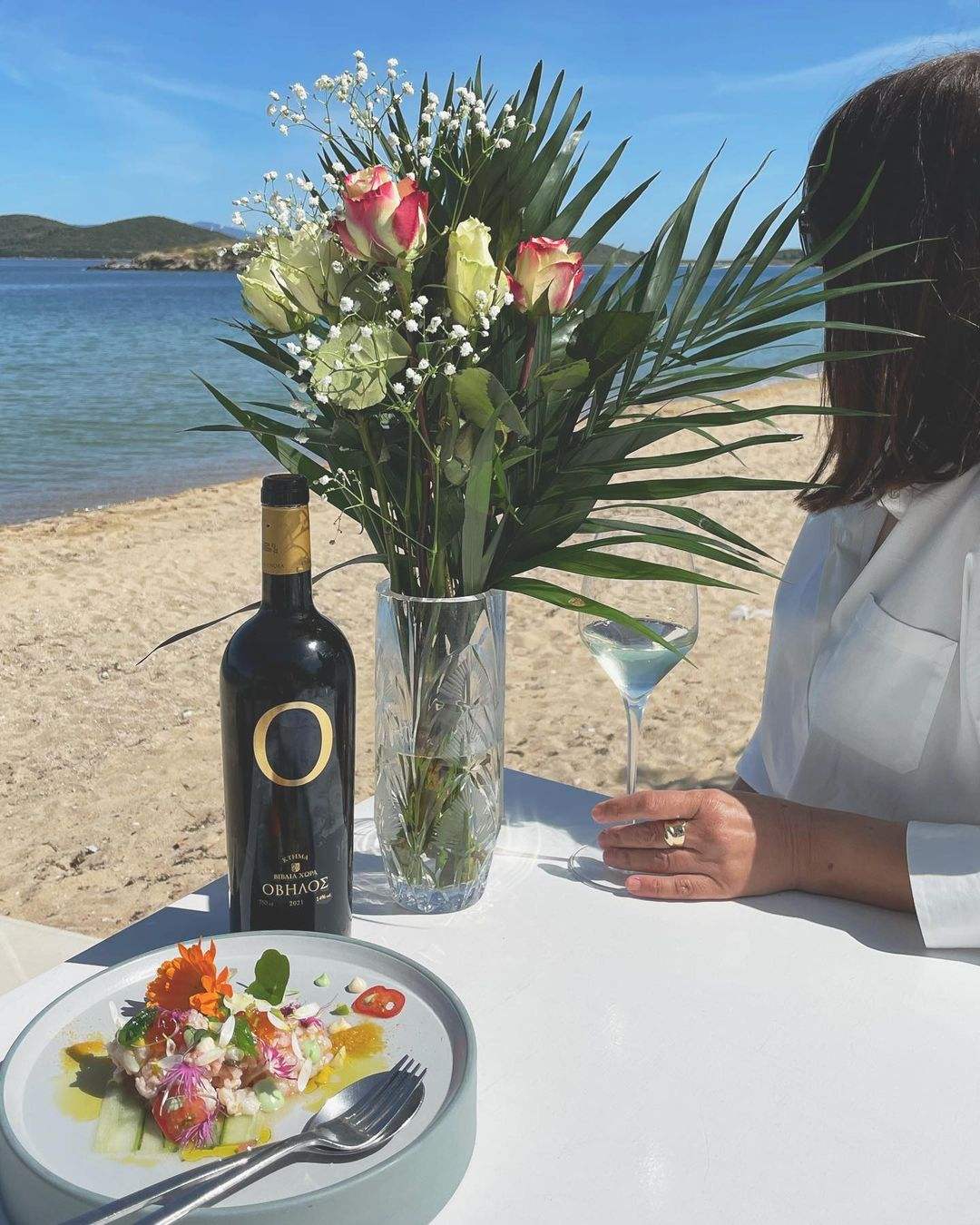 Biblia Chora Ovilos White Weißwein Flasche am Strand mit Blumen und Glas
