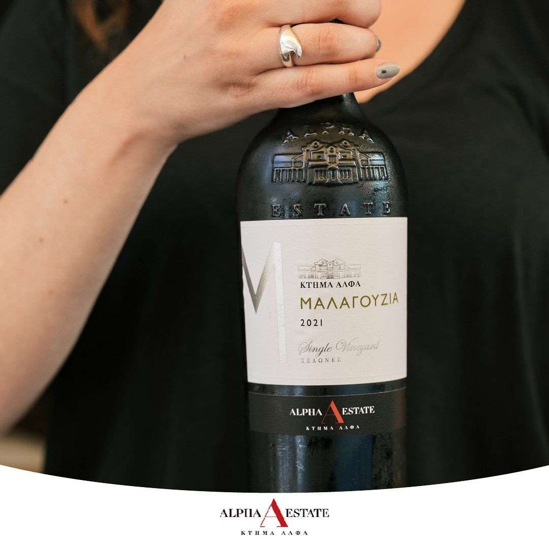 Alpha Estate Malagousia Weinflasche mit Etikett und Hand, griechischer Weißwein aus kühlem Klima