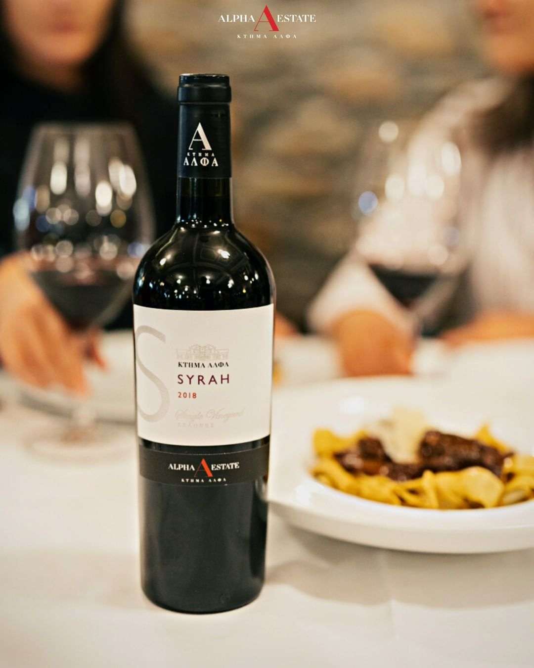 Syrah Turtles Weinflasche Alpha Estate mit Essen im Hintergrund