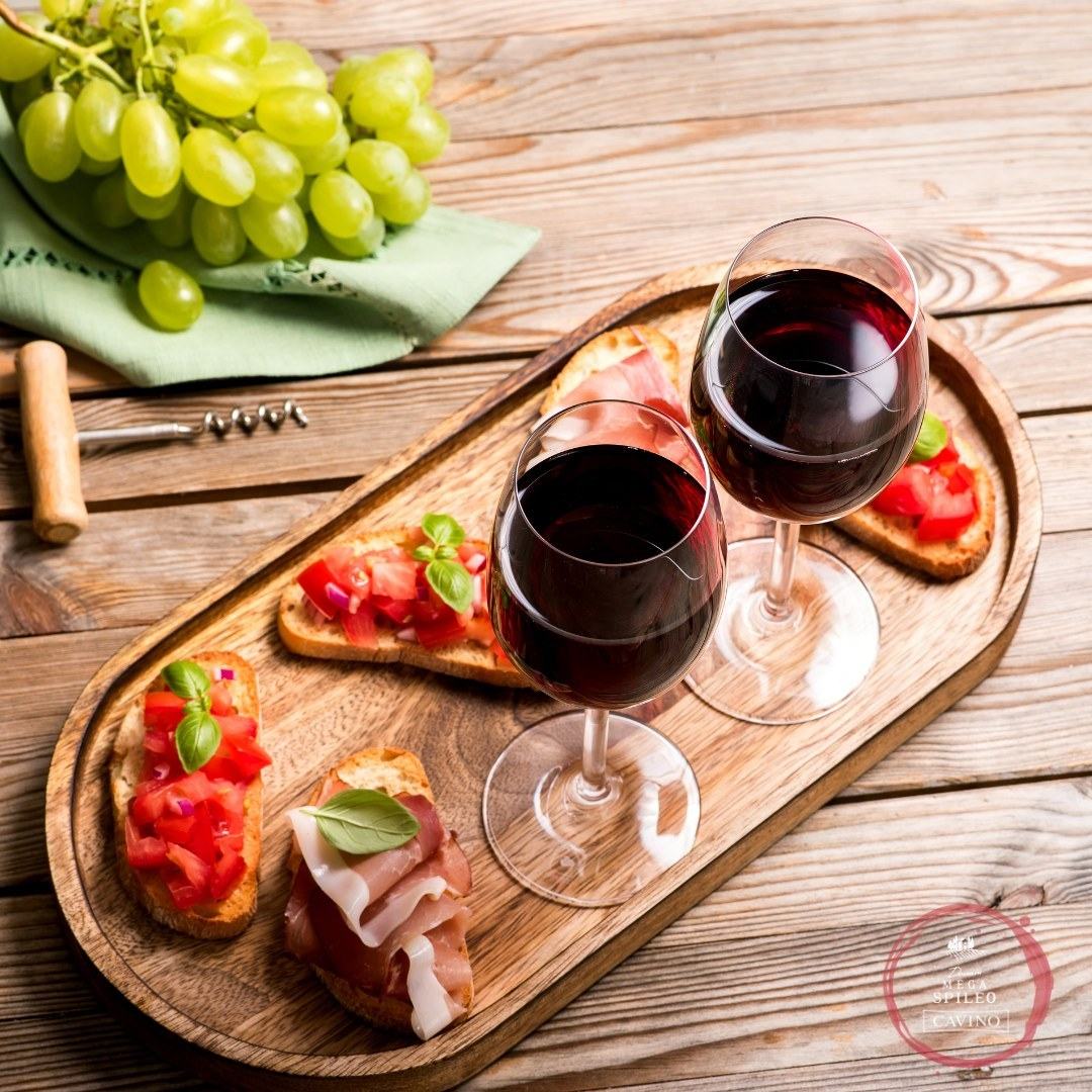 Mega Spileo Cabernet Sauvignon Rotwein mit Antipasti und Trauben auf Holzbrett