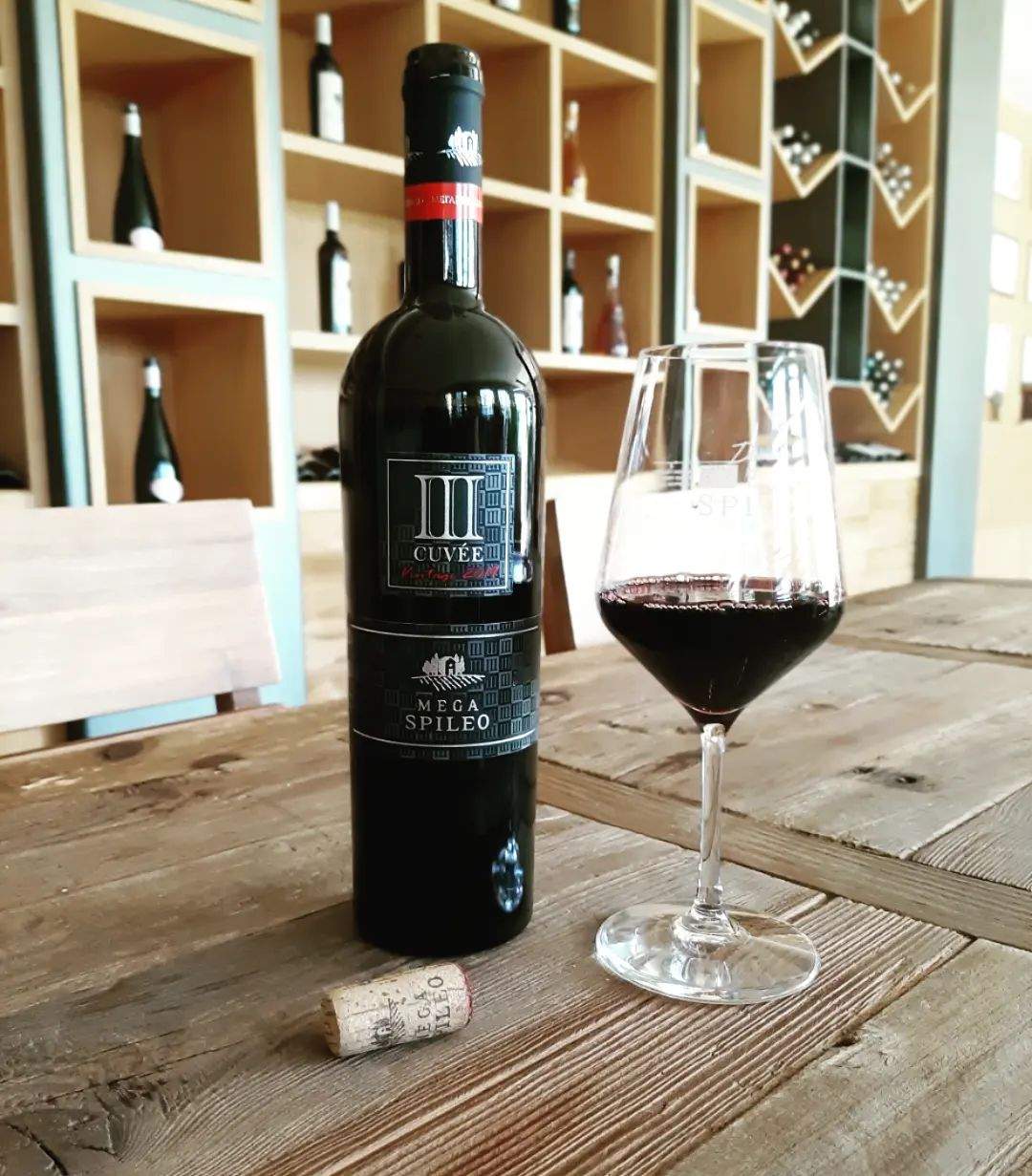 Mega Spileo Cuvee III Rot Weinflasche mit Glas voll trockener Rotwein aus Achaia PGI