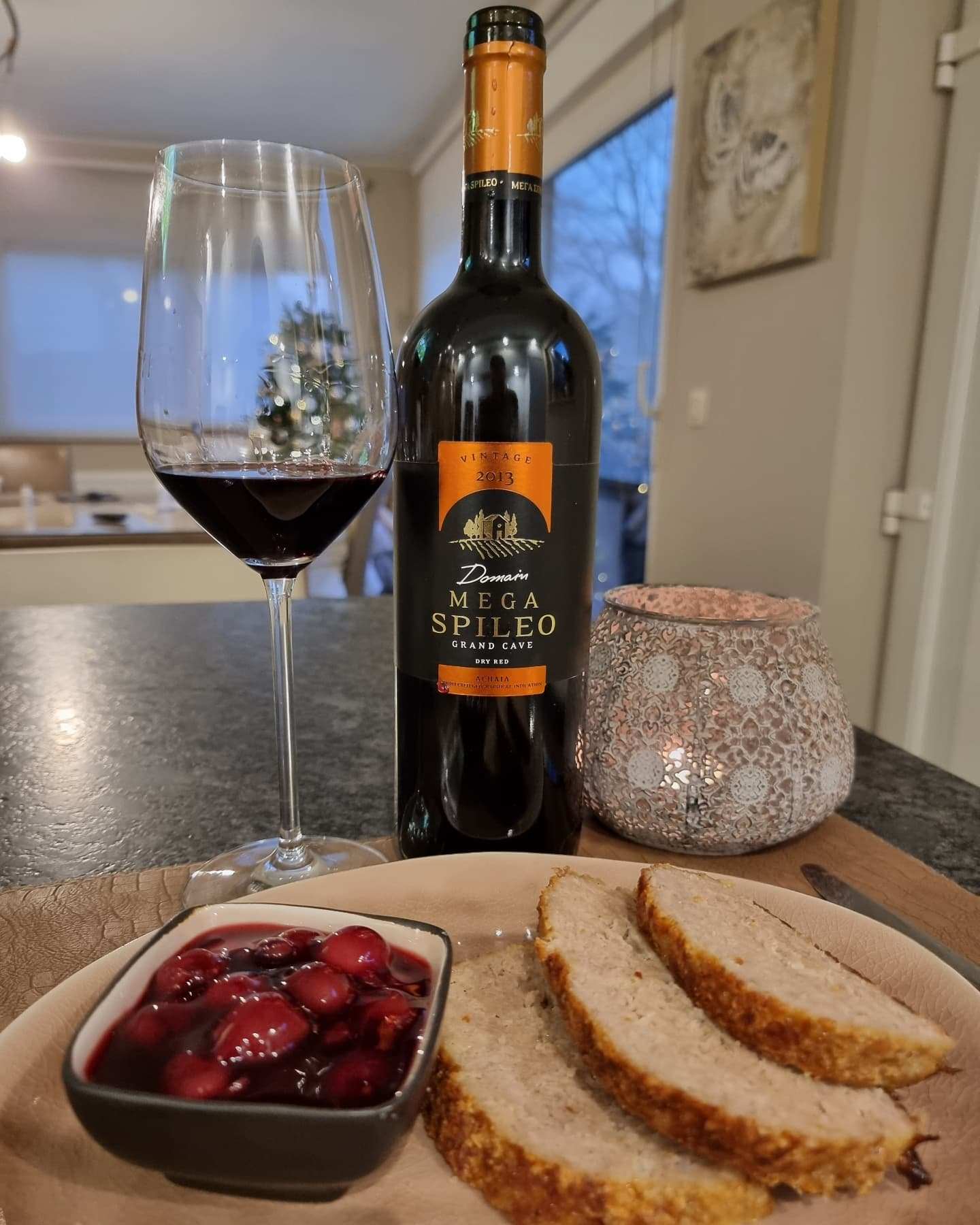Flasche Mega Spileo Grande Cave Rotwein mit Glas und Brot auf Tisch