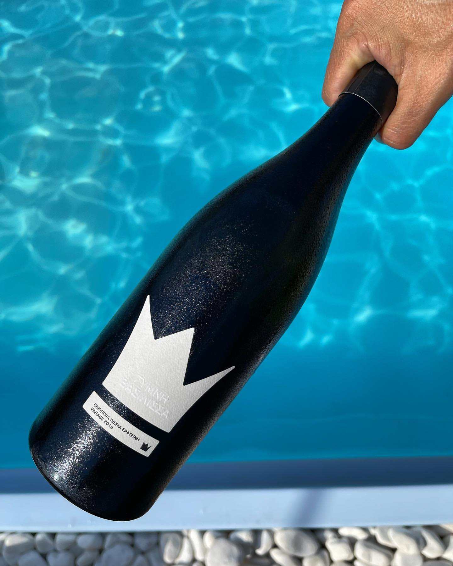 Schwarze Flasche von PIERIA ERATINI mit weißem Etikett, Gymni Vasilisa Wein aus Assyrtiko, trocken und Holzfass ausgebaut.
