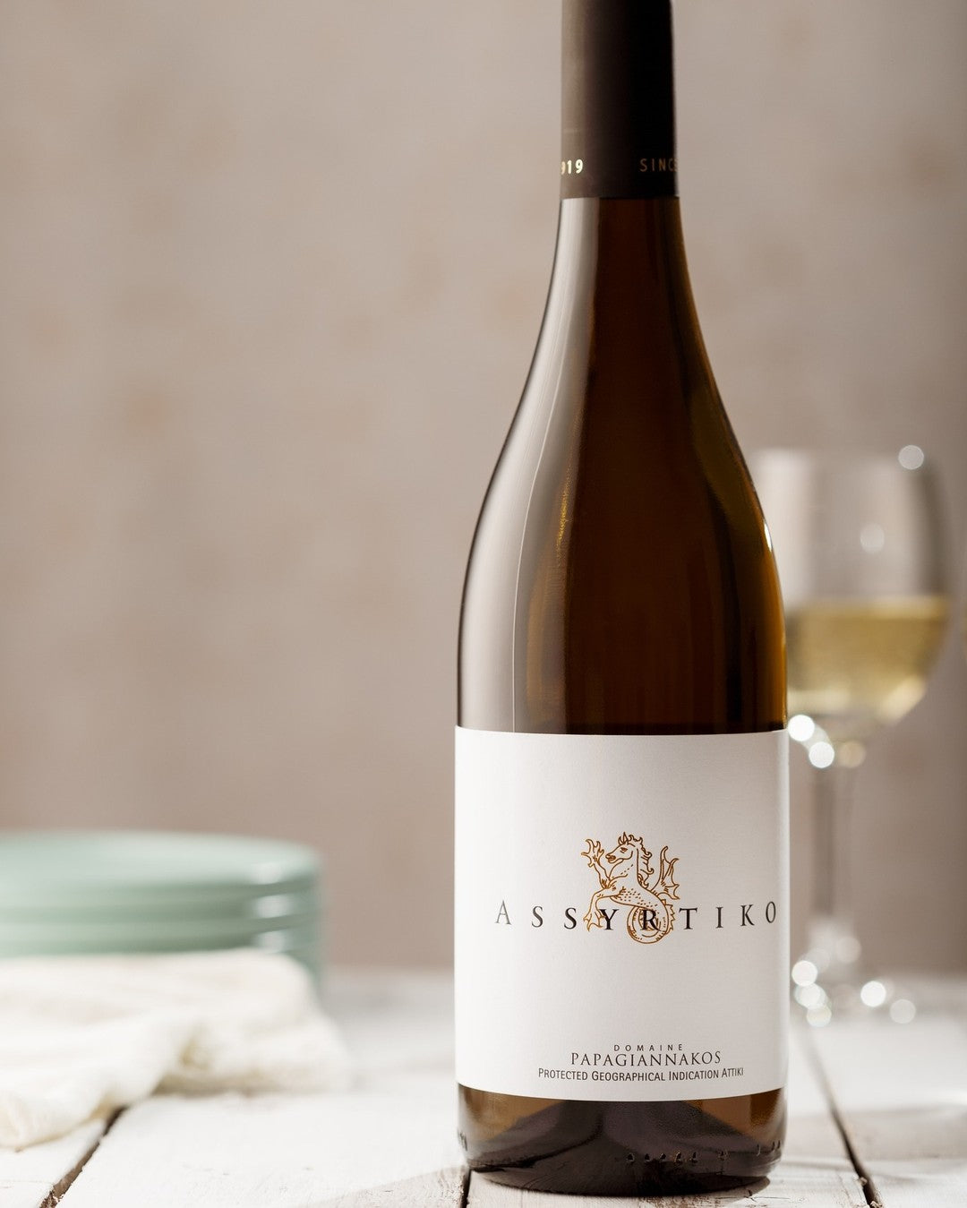 Assyrtiko Weißwein in einer Flasche mit eleganter Etikette und goldenen Akzenten