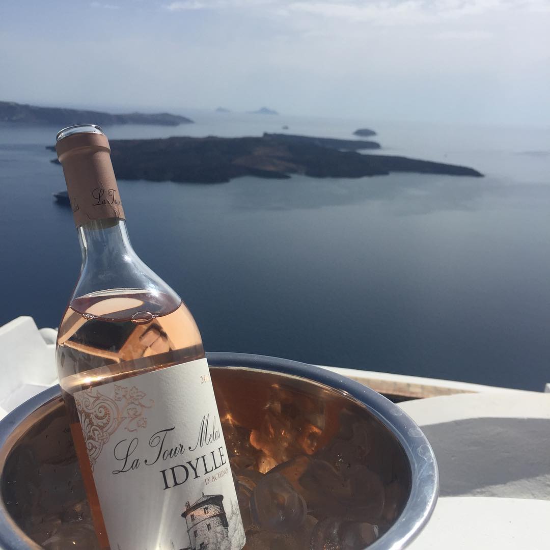 Griechischer Roséwein &quot;La Tour Melas Idylle&quot; in Meererandigkeg mit Blick auf idyllische Inseln vor Santorini