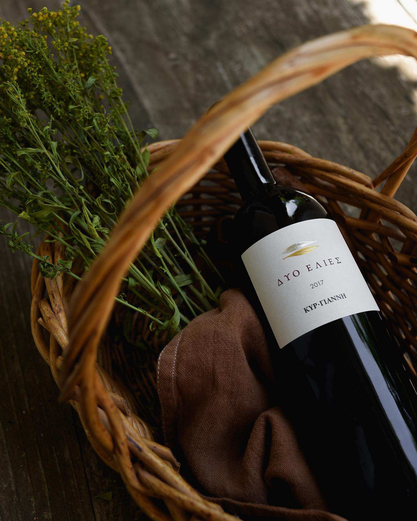 Dyo Elies Kir Yianni Estate Magnum Rotwein 2018er in einer Weidenkorb mit Kräutern und Stoffunterlage