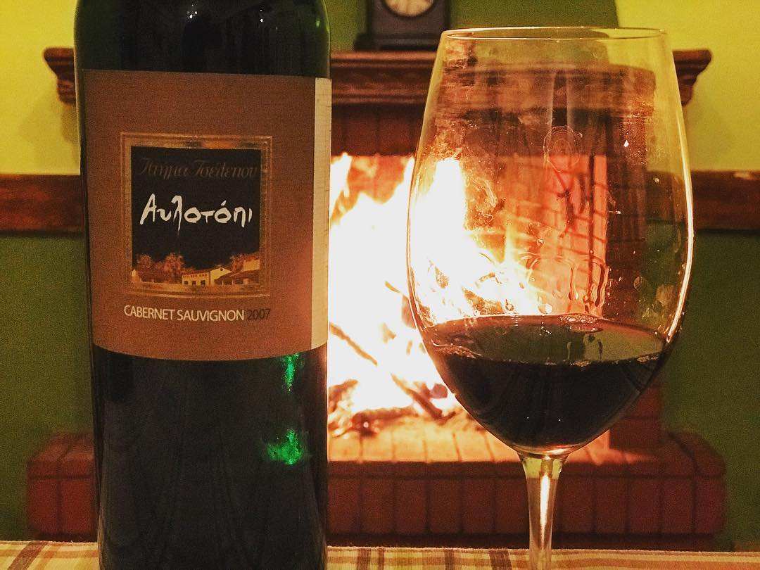 Tselepos Avlotopi Cabernet Sauvignon 2007 Flasche und Glas vor Kaminfeuer